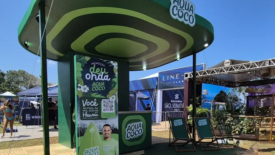Totem da promoção Deu Onda, da AQUACOCO, em frente ao estande na arena da WSL.